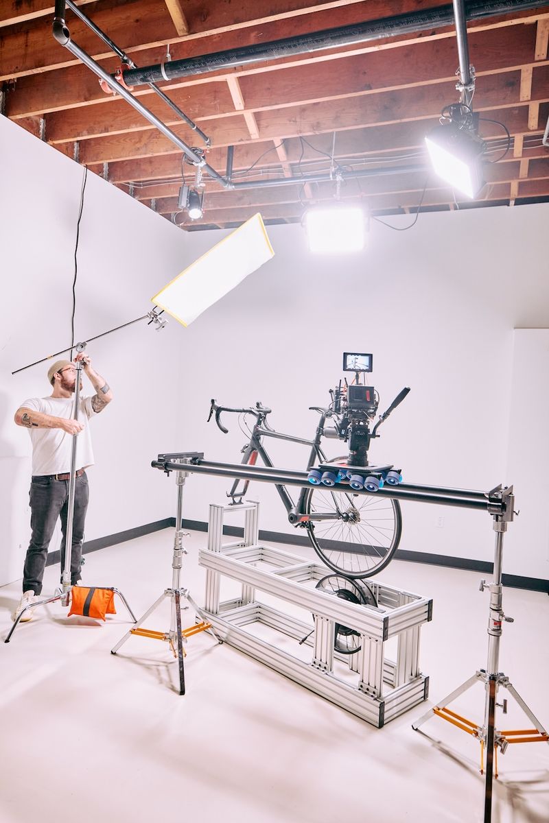 Wide view of the studio with a bike rigged on a motion-control slider and overhead lighting