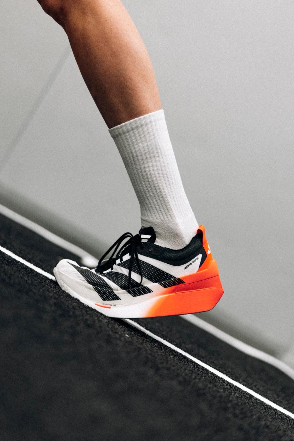 Adidas Adizero Dropset Elite hybrid training shoe in technical colorway, side profile view showing responsive midsole and reinforced heel counter