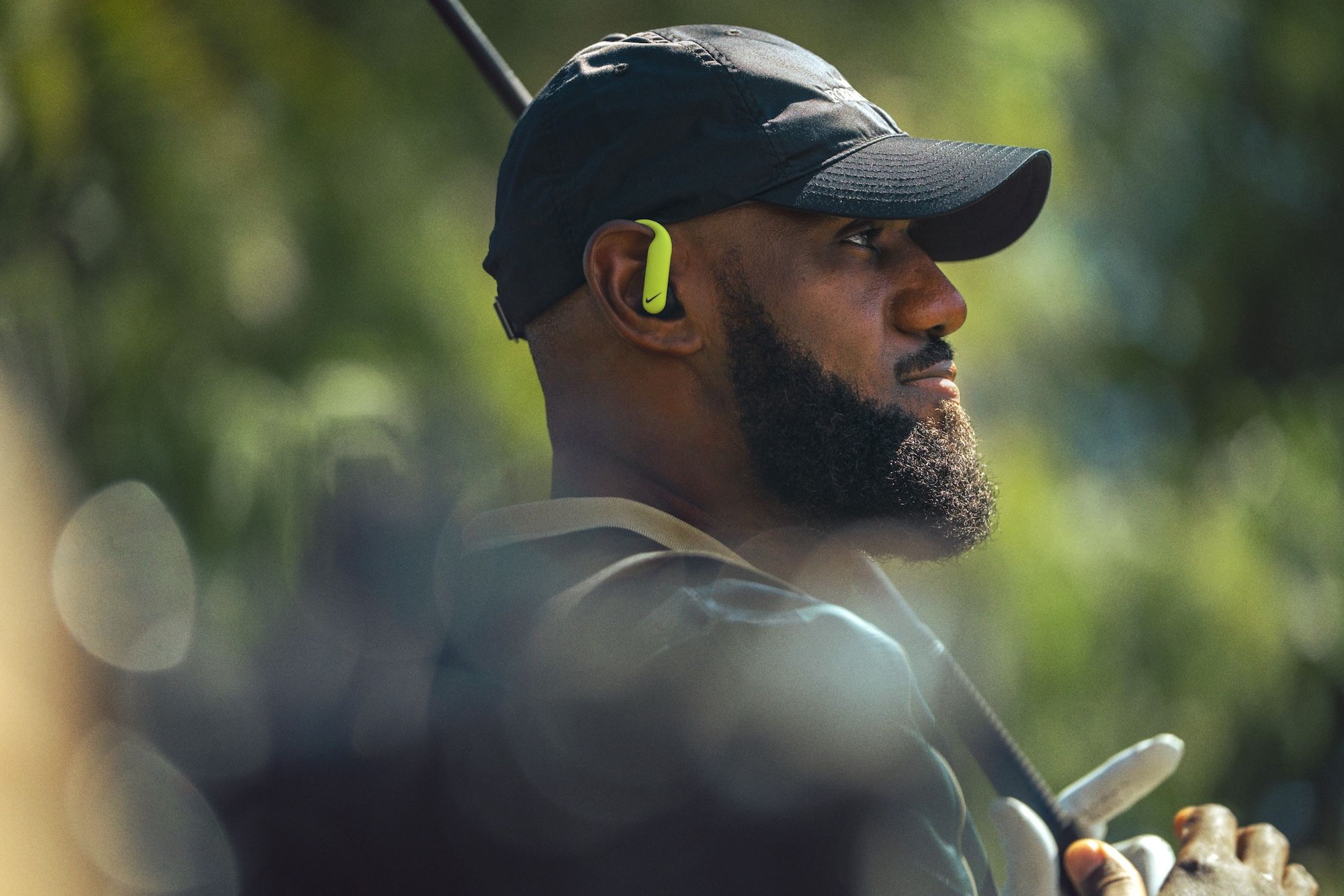 NBA superstat LeBron James wearing a black-and-volt-colored Powerbeats Pro 2 earbuds collaboration by Nike.