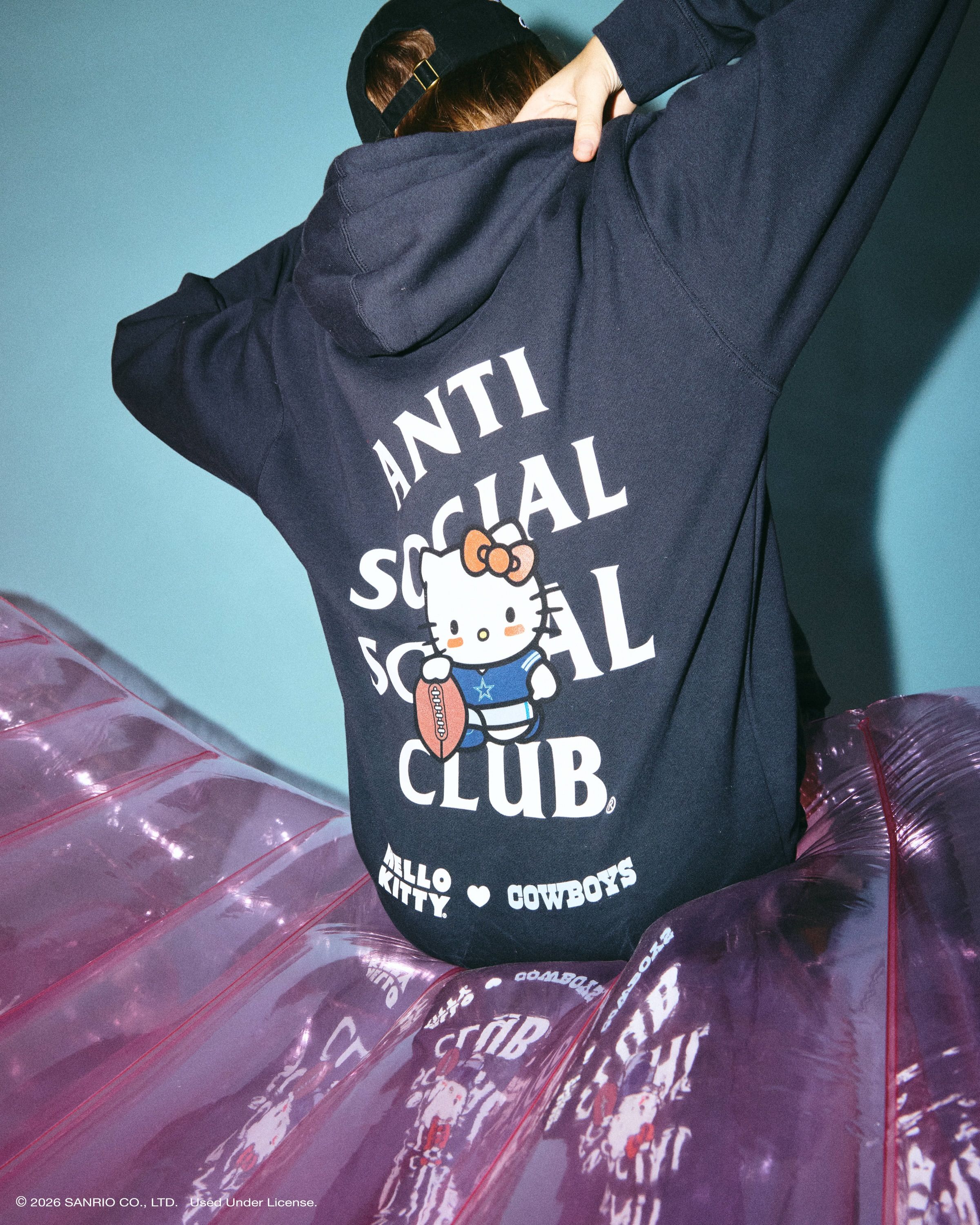 Anti Social Social Club × Hello Kitty NFL collection: navy Dallas Cowboys hoodie with Hello Kitty and ASSC logo on the back, lookbook photo via House of Heat