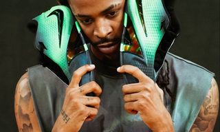 Ja Morant holding a green-and-black pair of his Nike Ja 4 basketball shoe.