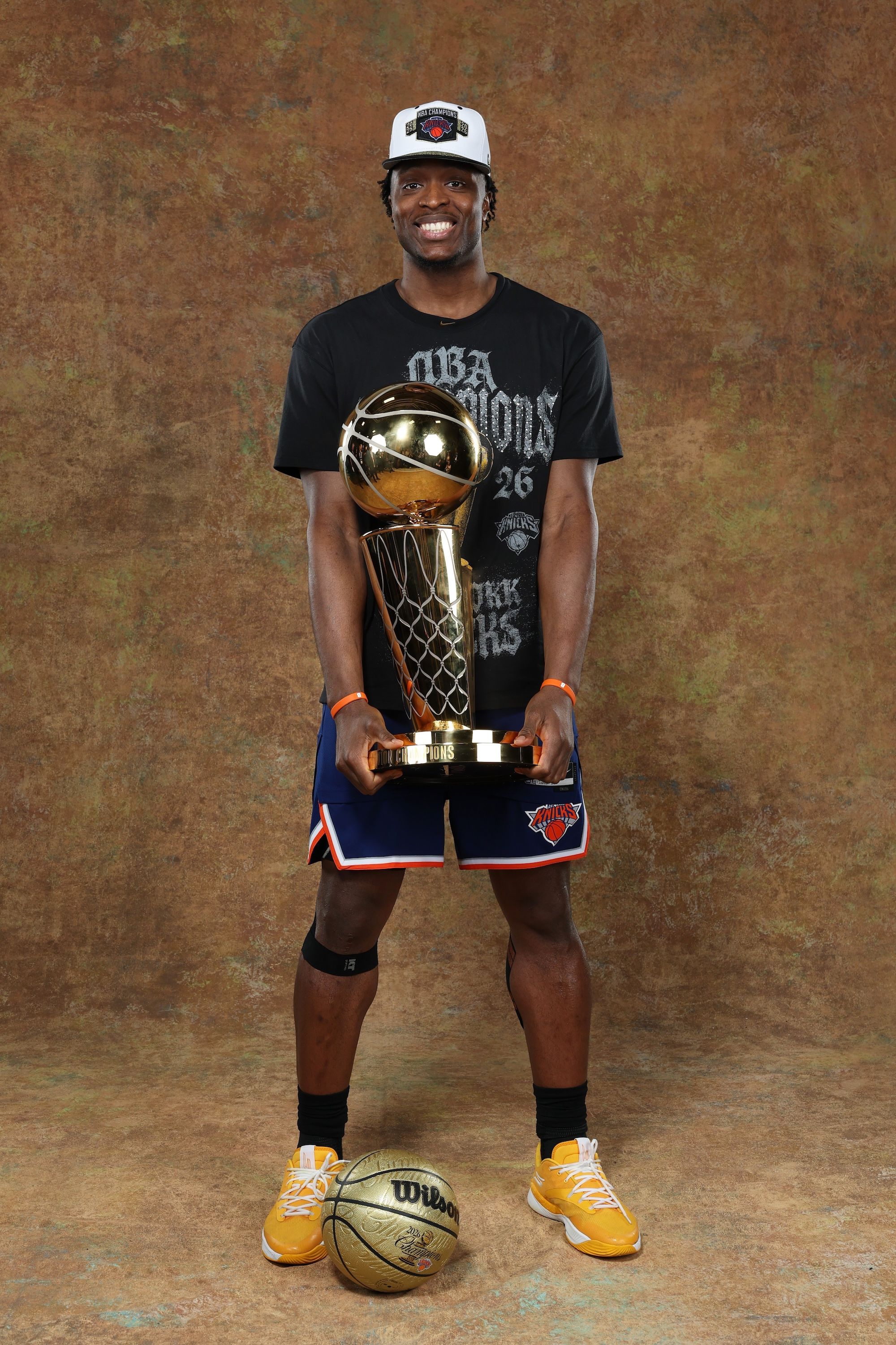 New York Knicks player OG Anunoby holding the Larry O'Brien Championship Trophy while wearing Skechers Basketball shoes.