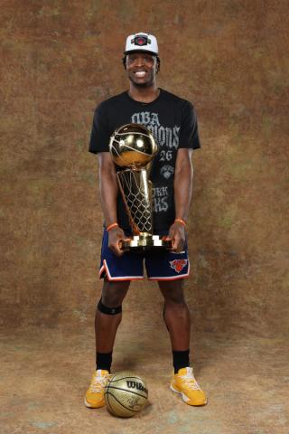 New York Knicks player OG Anunoby holding the Larry O'Brien Championship Trophy while wearing Skechers Basketball shoes.