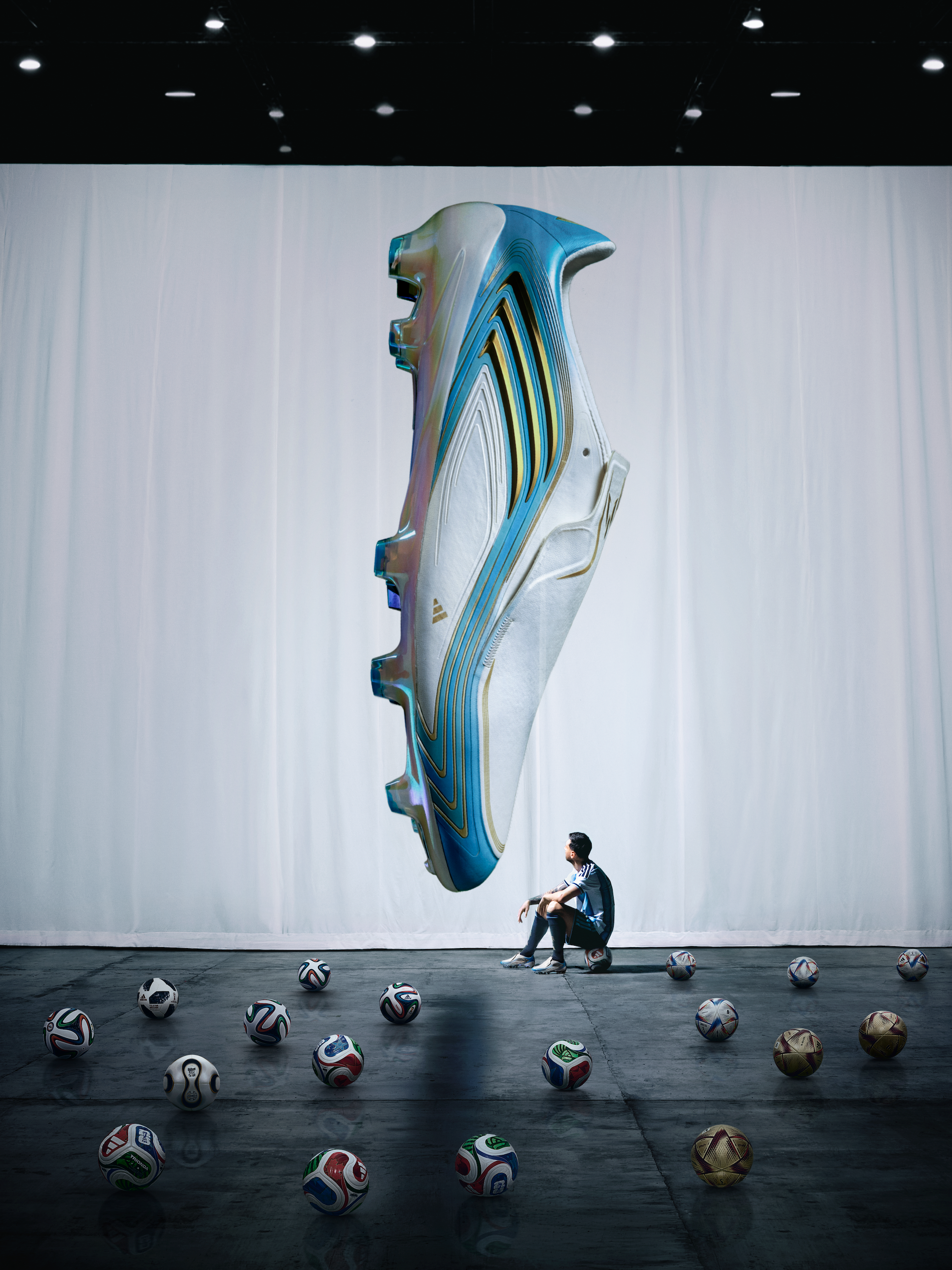 Lionel Messi sitting in front of his "El Último Tango" 2026 World Cup™ F50 boots while surrounded by 17 adidas match balls that represent his 17 World Cup™ goals.