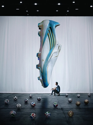 Lionel Messi sitting in front of his "El Último Tango" 2026 World Cup™ F50 boots while surrounded by 17 adidas match balls that represent his 17 World Cup™ goals.