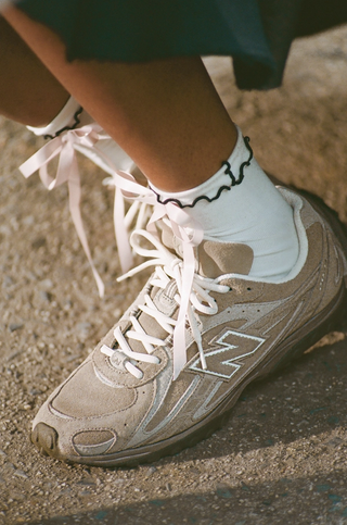 Trendy, thin-soled New Balance 204L sneaker in a mushroom color scheme.