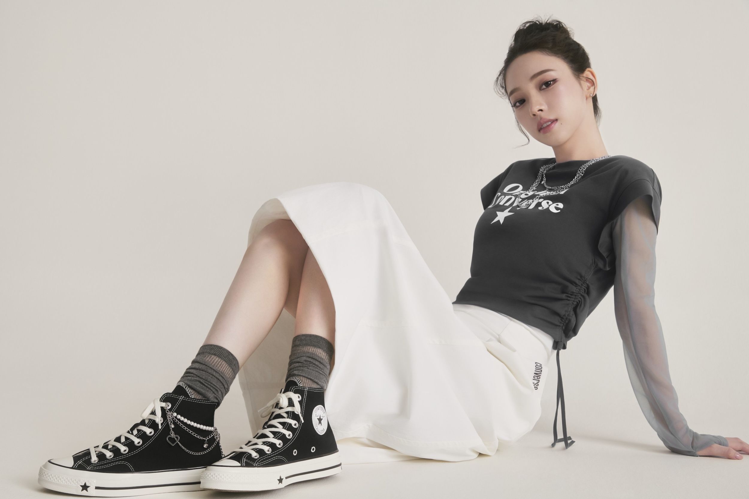 aespa's KARINA wears "Original Converse" t-shirt & a black pair of the Chuck 70 X to announce Converse deal.