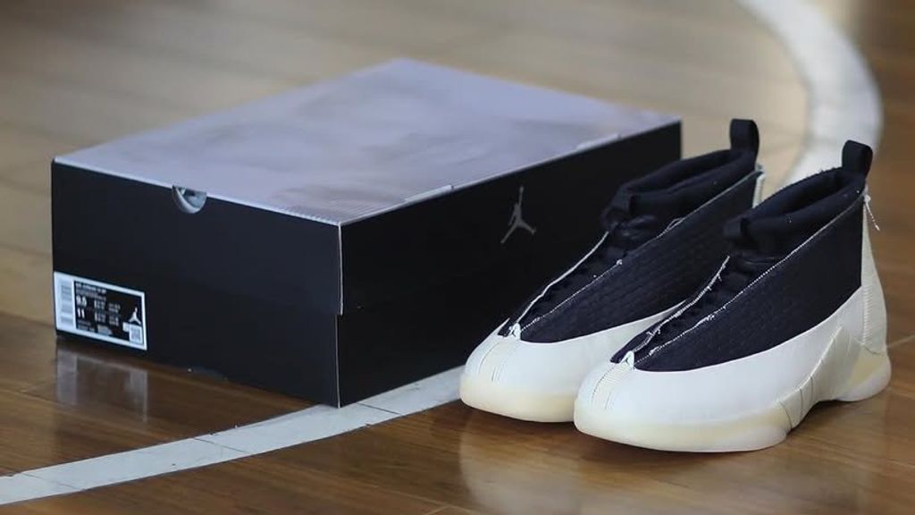 Air Jordan 15 23RE in Black Muslin colorway, side profile showing the mid-cut silhouette and carbon fiber shank detail