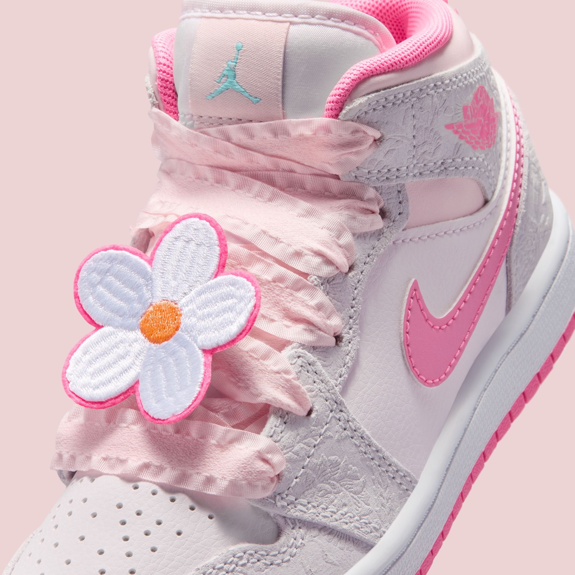Little Kids' Air Jordan 1 Mid in a "Vast Grey/Sail/Pink Bloom/Pink Glow" color scheme, complete with lace laces and flower adornments.