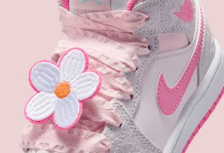 Little Kids' Air Jordan 1 Mid in a "Vast Grey/Sail/Pink Bloom/Pink Glow" color scheme, complete with lace laces and flower adornments.