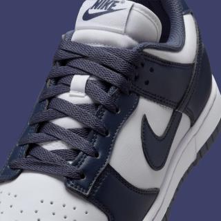Close-up view of Women's Nike Dunk Low covered in a "White/Thunder Blue" color scheme.