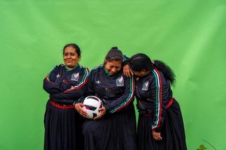 Three indigenous women artisans from Mexico's state of Puebla wearing a special, numbered edition of adidas' 2026 Third Jersey for the Mexico national football team.