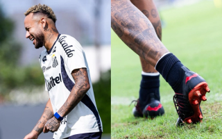 Neymar Jr. wearing a Batman-branded PUMA FUTURE football boot in black-and-red.