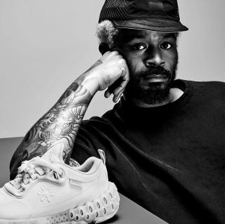 Salehe Bembury posing next to a debut style of his SPUNGE Osmosis sneaker design.