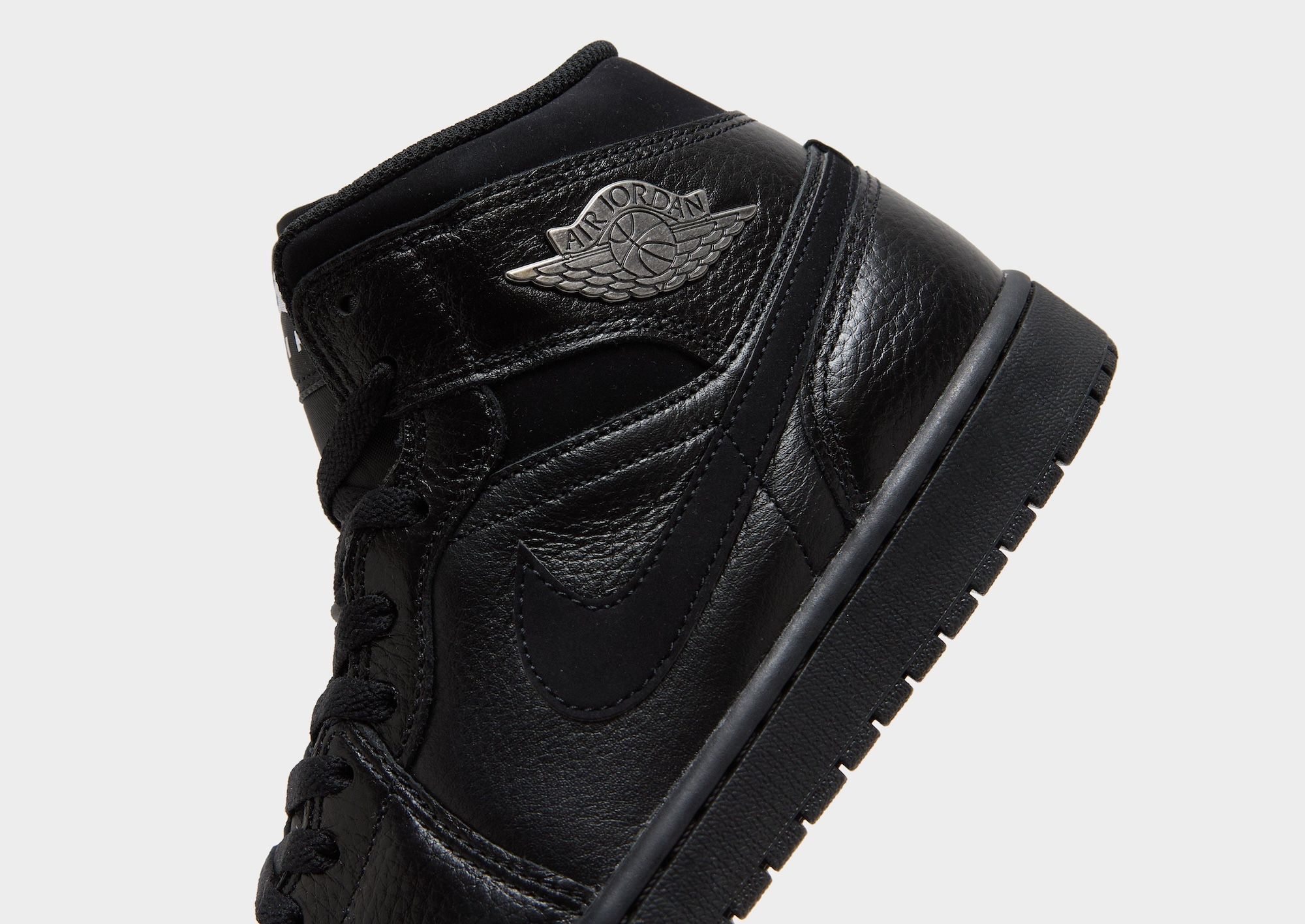 Men's Air Jordan 1 Mid retro in a black leather build complete with silver Wings logos. Photo via JD Sports.