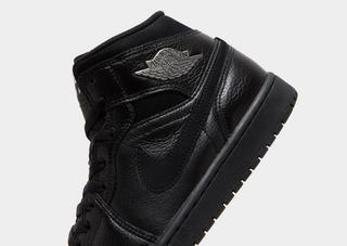Men's Air Jordan 1 Mid retro in a black leather build complete with silver Wings logos. Photo via JD Sports.