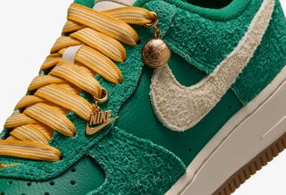 Nike Air Force 1 Low '07 "Game Day" sneaker in a "Malachite/University Gold/Gum Medium Brown/Coconut Milk" color scheme.