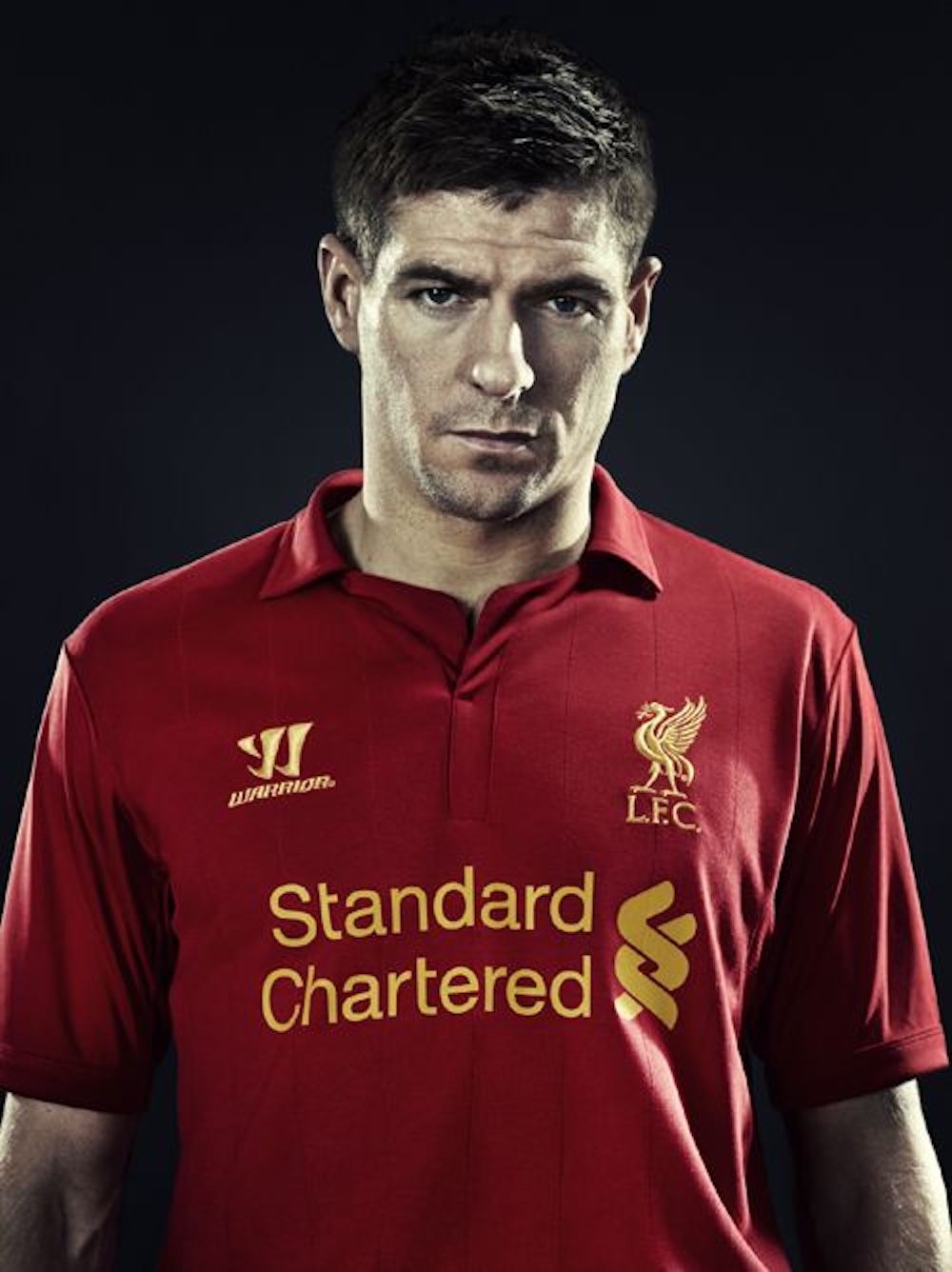 Steven Gerrard wearing Liverpool's 2012/13 Home Jersey by Warrior. Photo via Football Kit News.