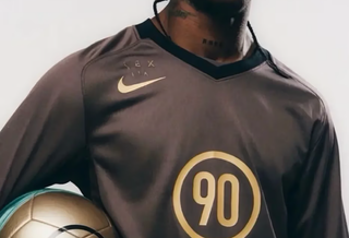 Travis Scott wearing a Cactus Jack-branded Nike Total 90 football jersey.