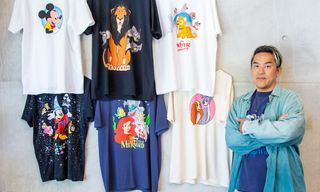 Bobby Kim, Global Creative Director, Disney Consumer Products, posing next to six graphic t-shirts from his Collection 1: Classics collaboration.