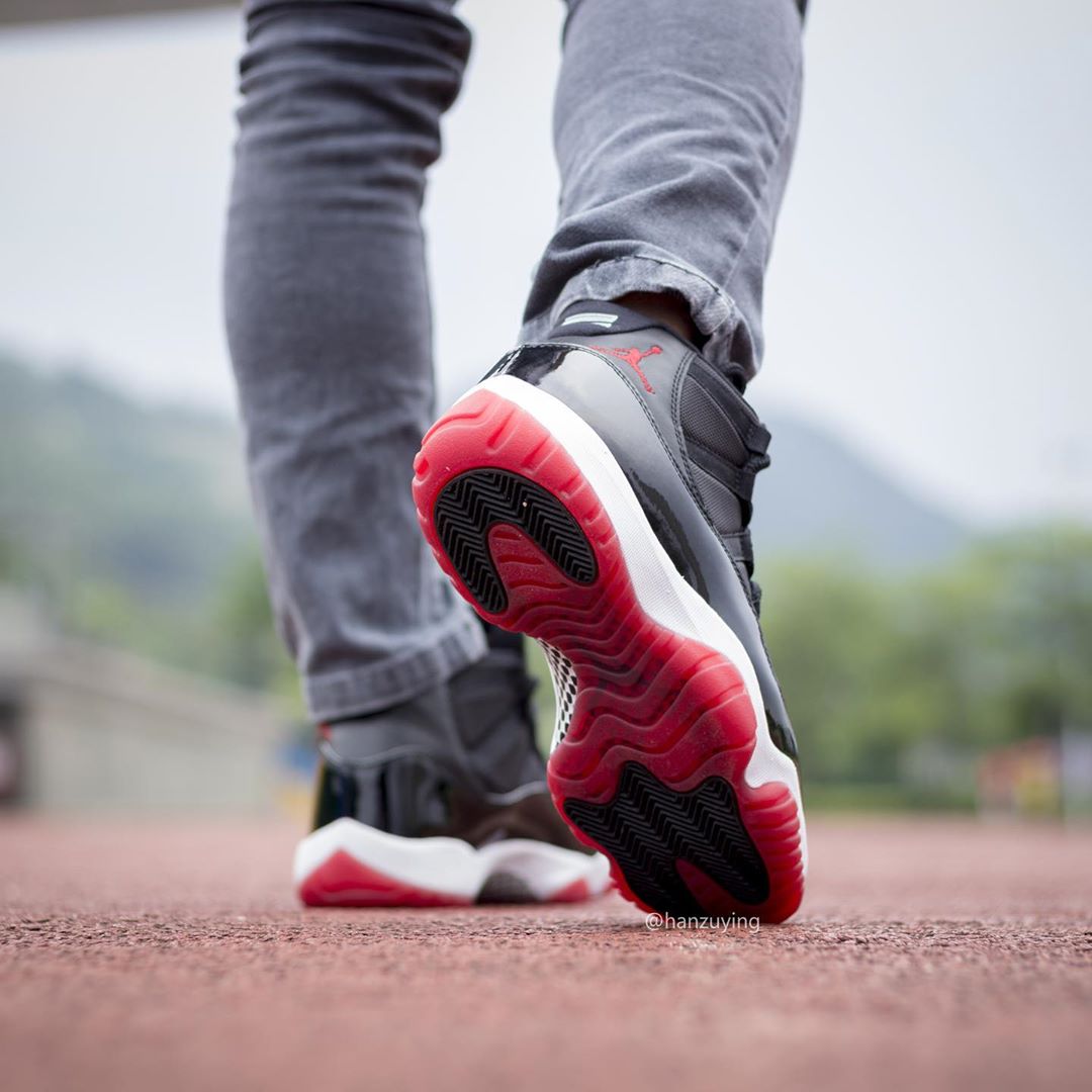 On foot. Air Jordan 11 High. Air Jordan 11 Retro bred 2019 on foot. Air Jordan on feet. Red and Black Jordan 11s on feet..