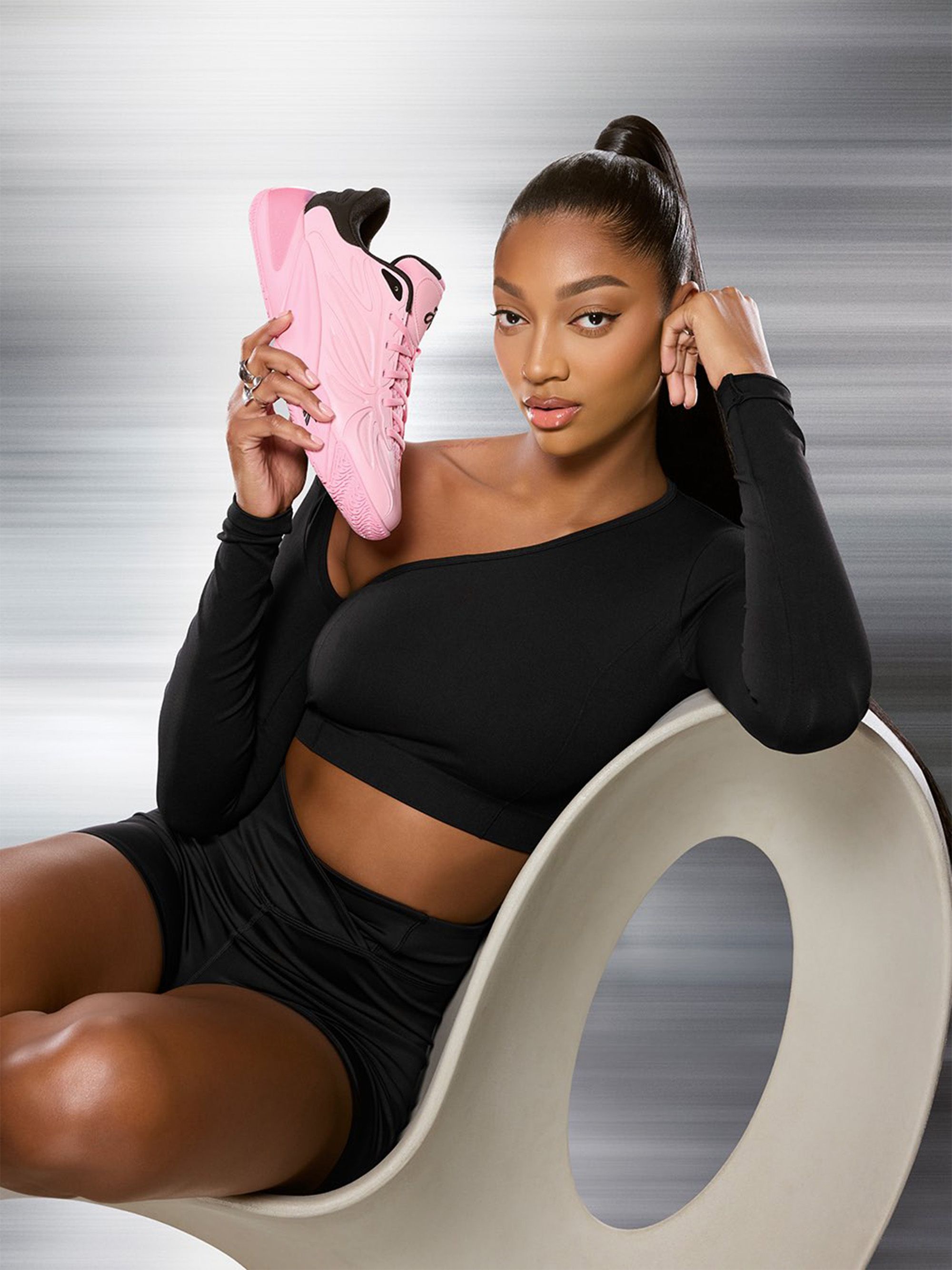 Angel Reese holding her “Expressive Pink” Reebok Basketball shoe. Photo via Reebok.