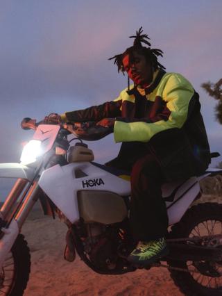 Smino wearing the HOKA Speedgoat 2 "Neon Yuzu/Bayleaf." Campaign Images via HOKA.