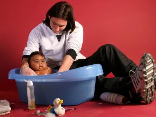 Lionel Messi bathing a baby Lamine Yamal. Photo by Joan Monfort for UNICEF via AP/ABC News.