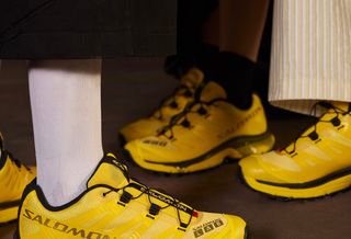 Campaign photo for Mundo Domingo x Salomon XT-4 OG sneaker collaboration in yellow-and-black.