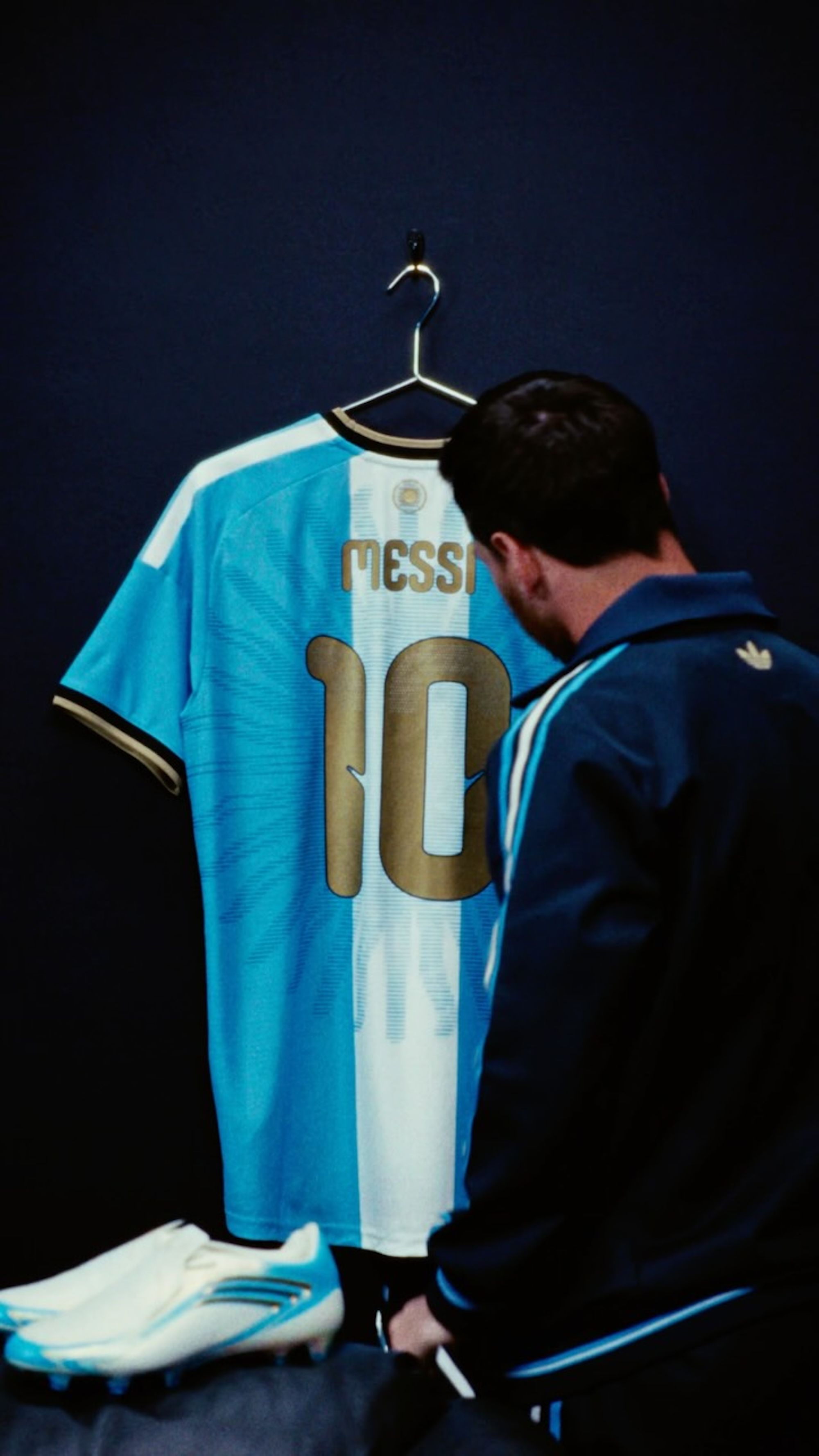Lionel Messi standing in front of his special-edition, final Argentina Home jersey made by adidas.