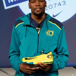 Kevin Durant holding the Nike KD 6 "Seat Pleasant" basketball shoe at a launch event in July 2013.