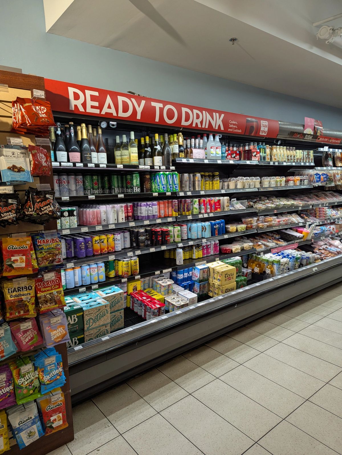 Red Ready to Drink header running along a Rabba cooler aisle stocked with wine, beer and coolers