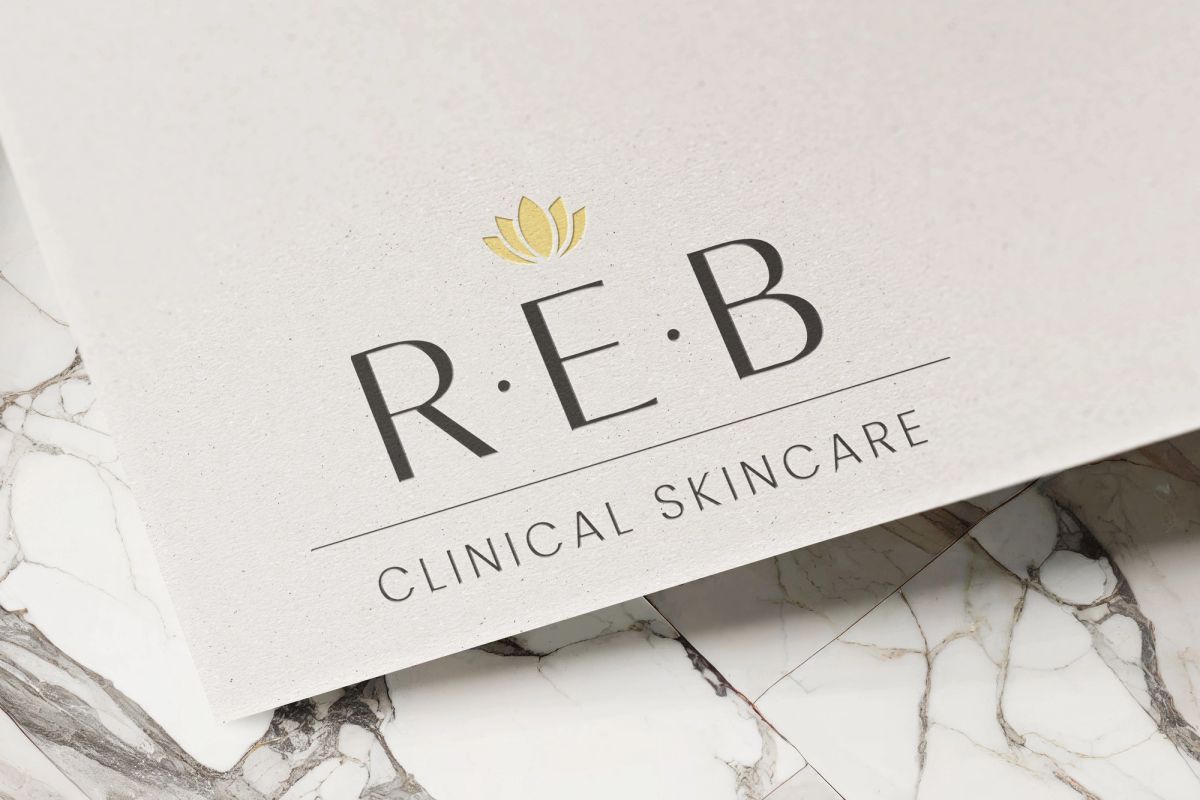 REB Clinical Skincare logo printed on textured card over white marble