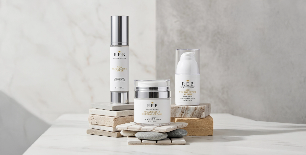 REB serum, cream jar and pump bottle styled on stacked stone and marble