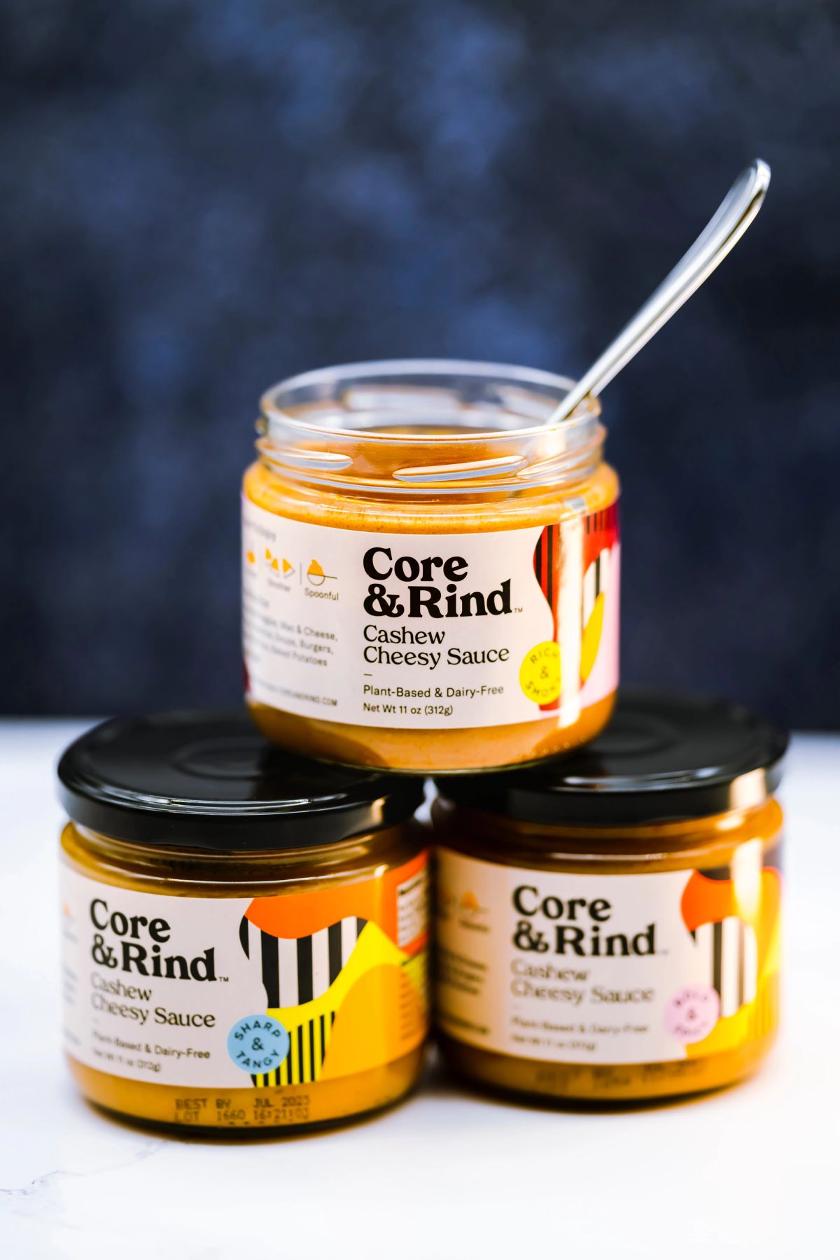 Stylishly labeled jars of Core & Rind Cashew Cheesy Sauce, showcasing plant-based and dairy-free goodness with eye-catching design.