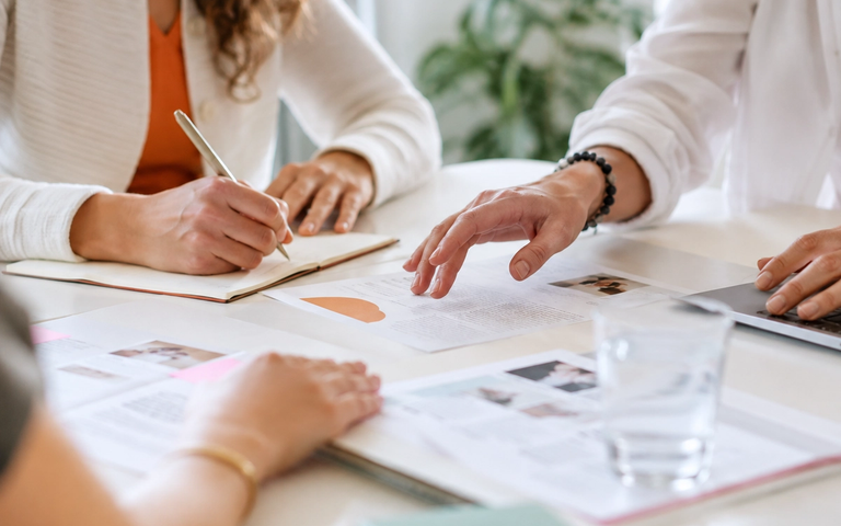 Gruppe von Frauen sitzt im Gespräch an einem Tisch