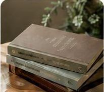 Stapel gebundener Bücher auf einem Holztisch