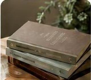 Stapel gebundener Bücher auf einem Holztisch