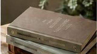 Stapel gebundener Bücher auf einem Holztisch