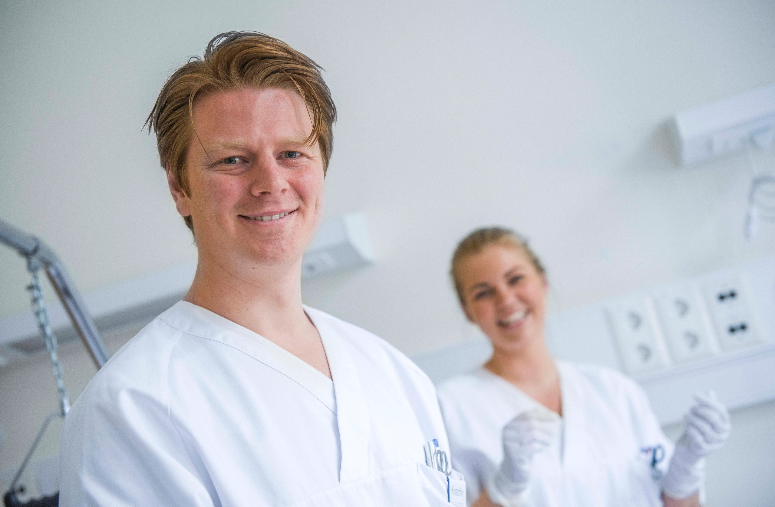 To sykepleierstudenter i praksis på sykehus med hvite sykepleierdrakter.