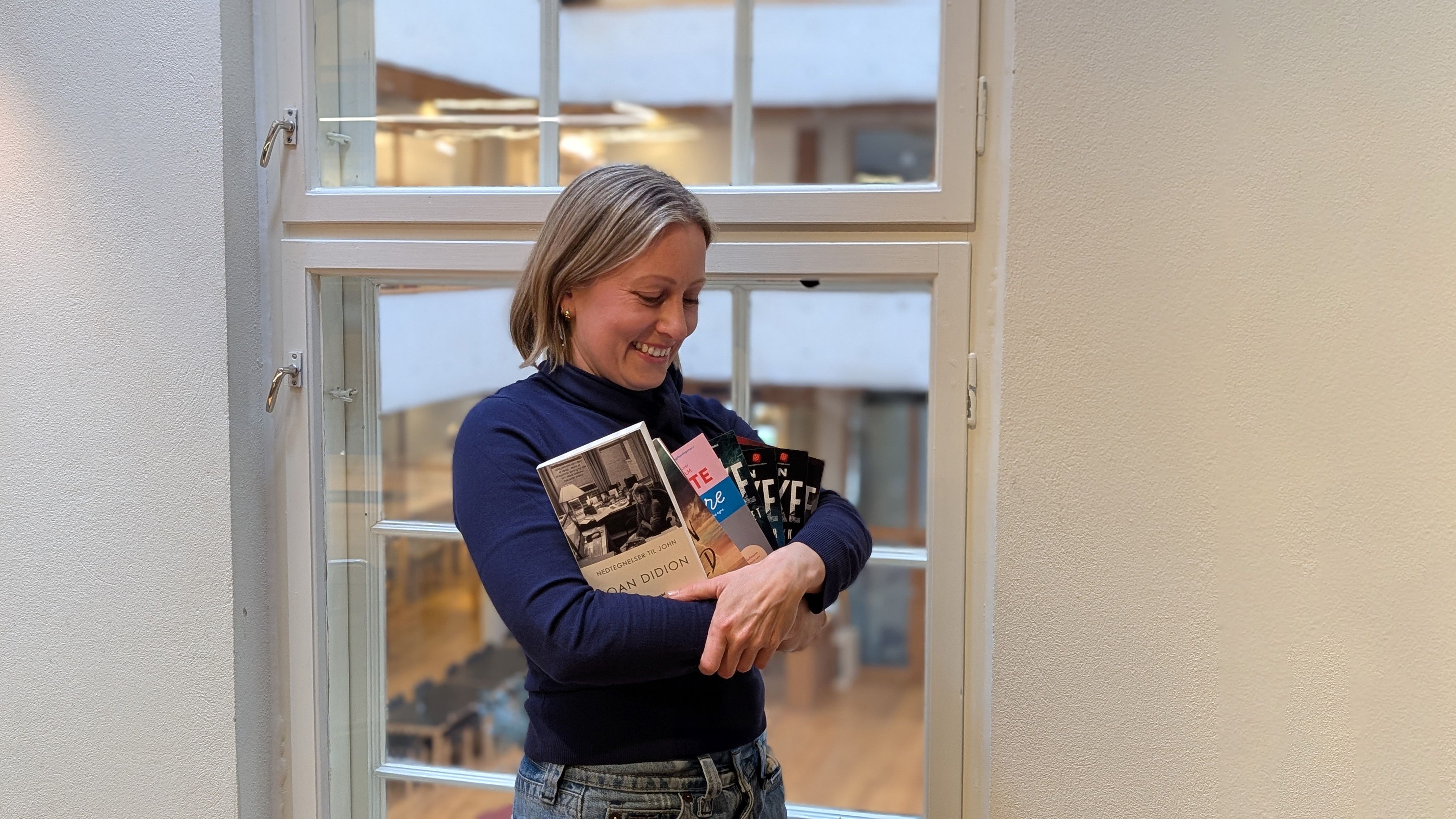 Foto av en kvinne som holder bøker
