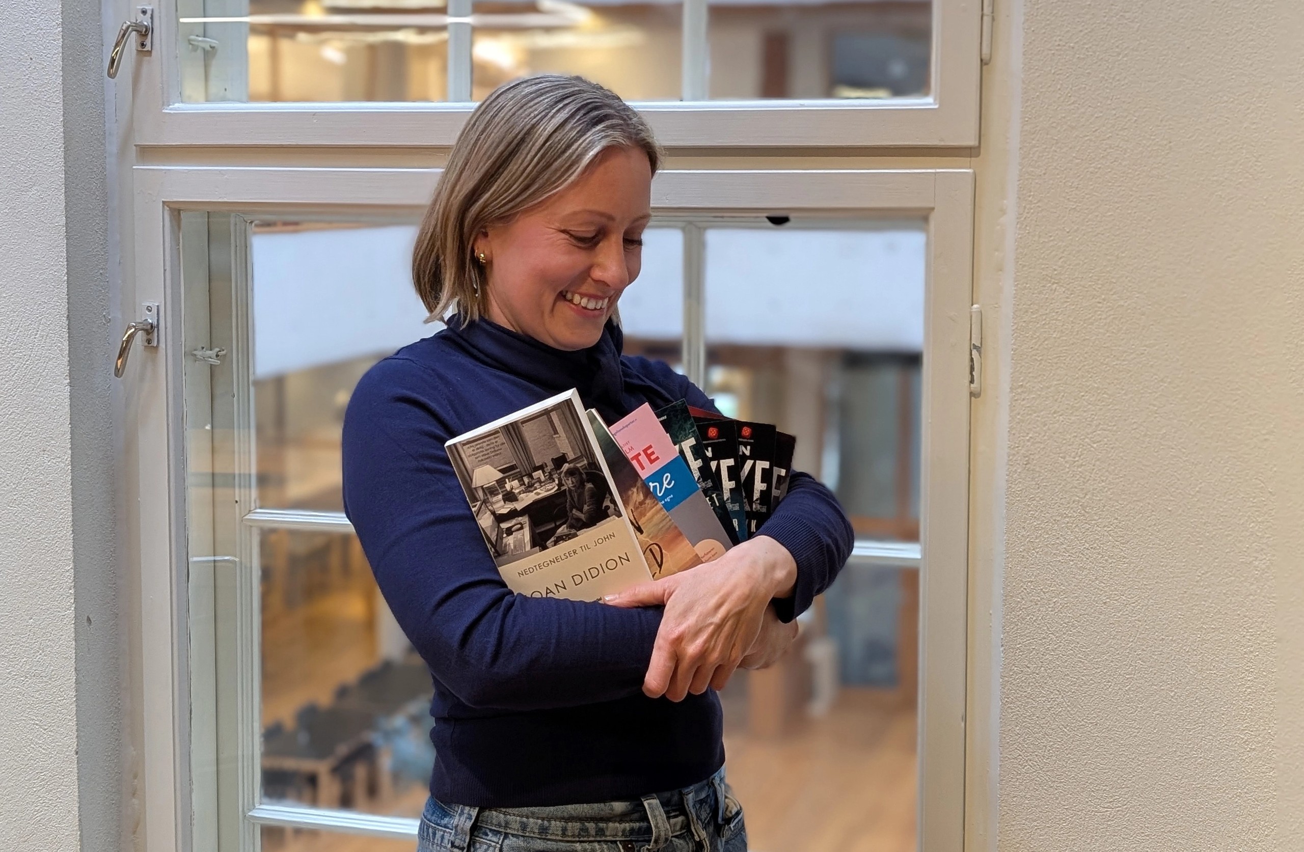 Foto av en kvinne som holder bøker