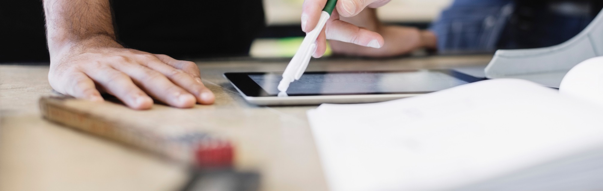Ipad og bok på en arbeidspult