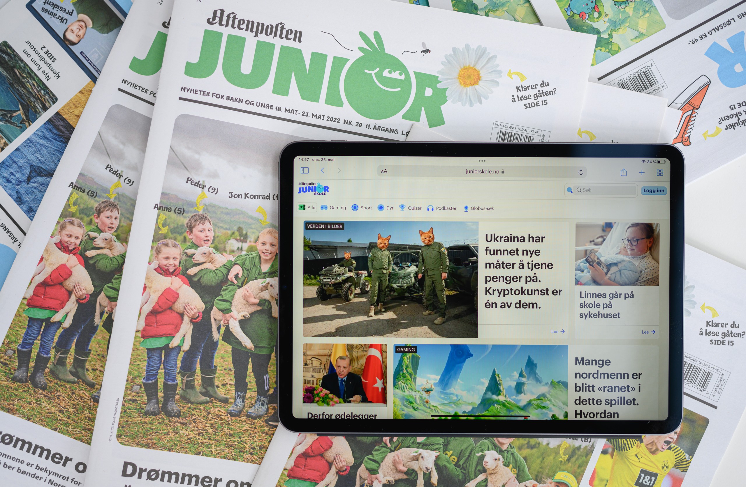 Foto, samling av Aftenposten Junior utgaver med Aftenposten Junior på ett nettbrett.