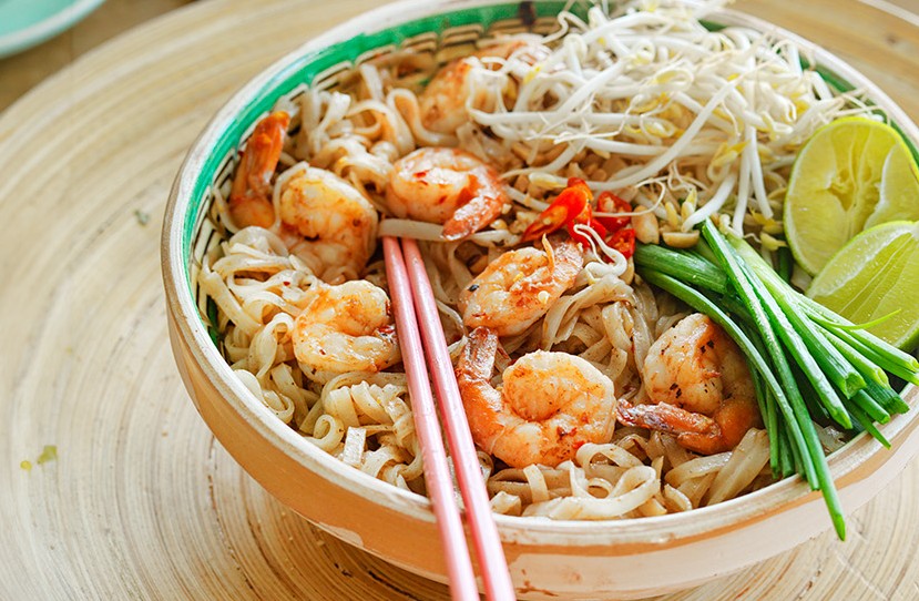 Bilde av en bolle med matretten pad thai og et par spisepinner