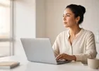 An accountant pausing at her laptop at a bright desk before cancelling a document.