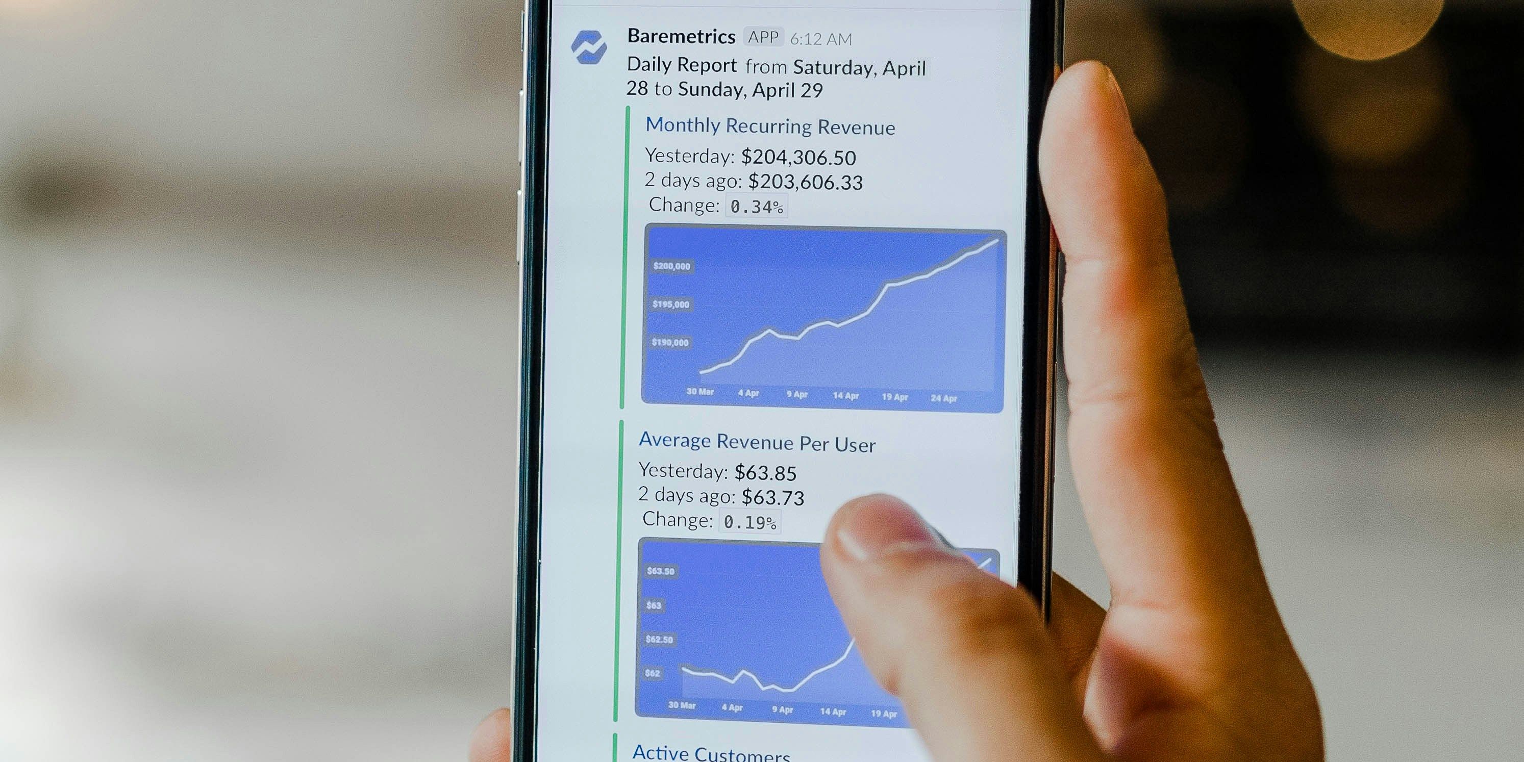 a person is holding a cell phone with a graph on the screen .