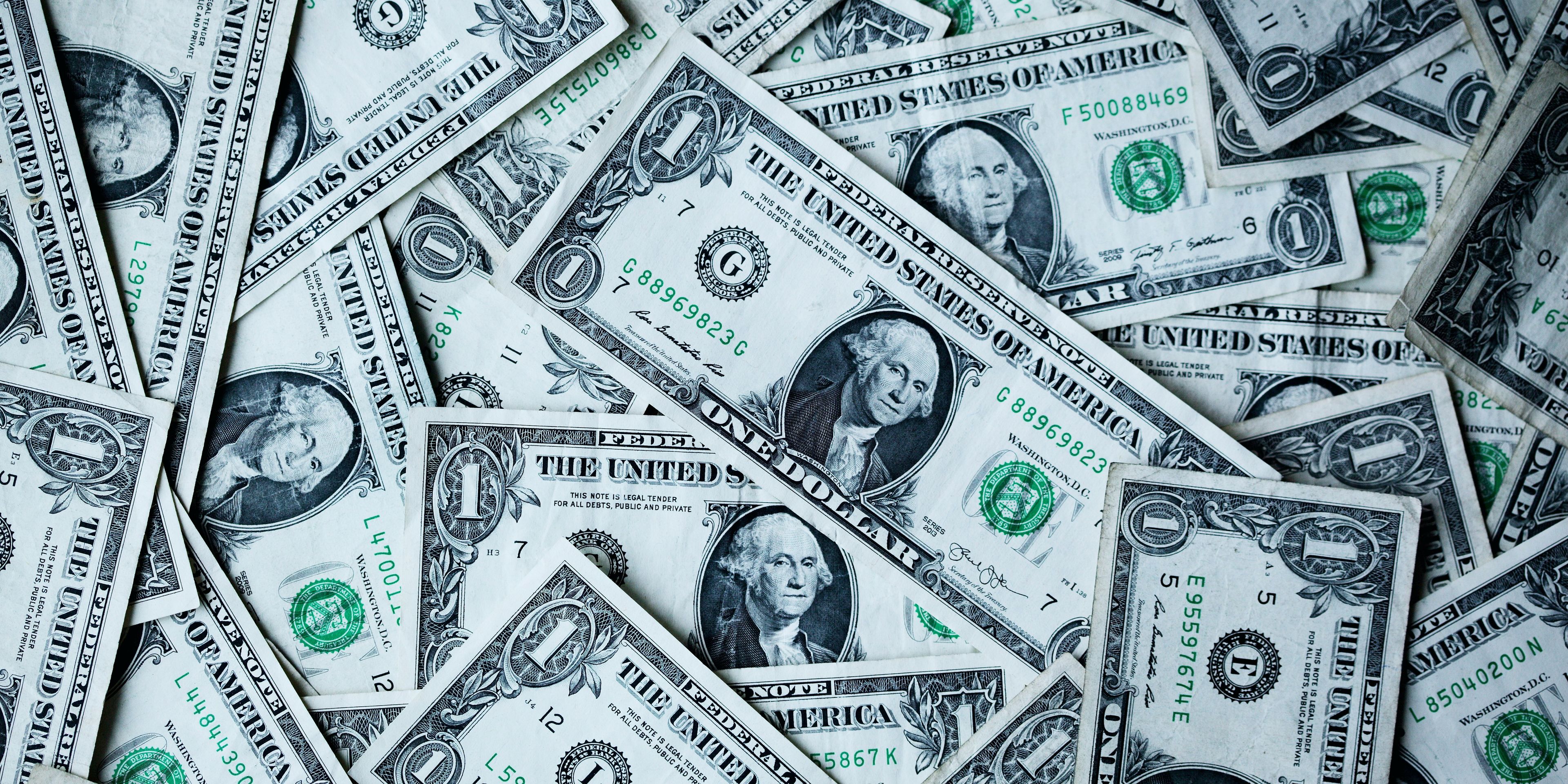 a pile of one dollar bills stacked on top of each other .