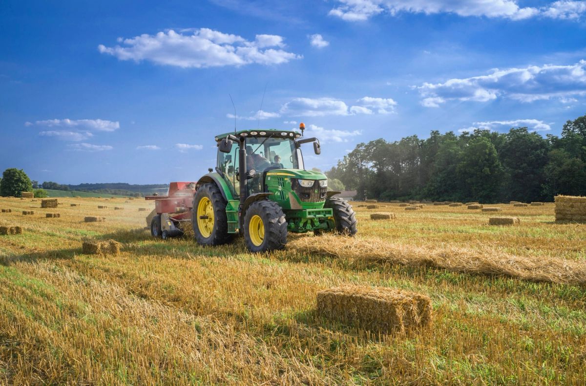 Tractor collecting hay bales at harvest
