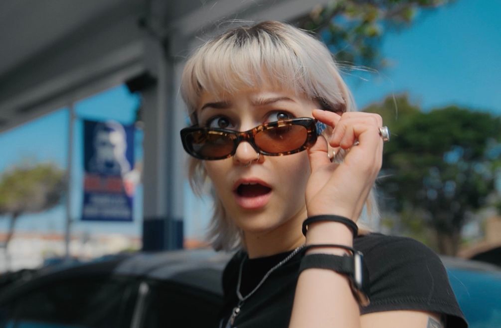 Emmy pulls down her sunglasses, looking shocked